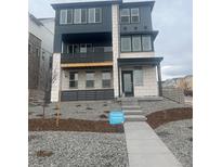 Modern two-story home with balconies, a stone facade, and professional landscaping at 8866 Waterleaf Ln, Littleton, CO 80125