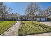 Charming home with walkway, lush lawn and mature trees, providing great curb appeal and a welcoming entrance at 4401 S Yosemite Ct, Greenwood Village, CO 80111
