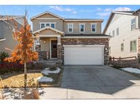 Charming two-story home featuring a stone facade and a well-maintained front yard at 15246 W 94Th Ave, Arvada, CO 80007