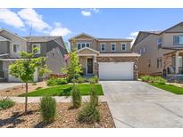 Beautiful two-story home with lush green lawn, charming landscaping, and inviting curb appeal at 15246 W 94Th Ave, Arvada, CO 80007