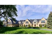 Expansive stone home with lush lawn and manicured landscaping boasts exceptional curb appeal at 4603 S Denice Dr, Cherry Hills Village, CO 80111