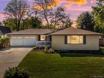 Charming single-story home with a well-maintained lawn, attached garage, and inviting front porch at 6943 Oak Way, Arvada, CO 80004