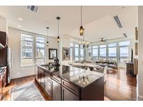 Modern kitchen with stainless steel appliances and a spacious island, seamlessly flowing into the living area at 5455 Landmark Pl # 413, Greenwood Village, CO 80111