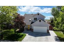 Charming two-story home featuring a well-manicured lawn, mature trees, and a welcoming facade at 10635 Dexter Dr, Thornton, CO 80233
