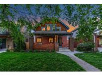 Charming brick two-story home with a well-manicured front lawn and inviting curb appeal at 890 S Vine St, Denver, CO 80209