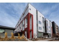 Modern townhouse featuring a striking white and grey facade with bold red accents and contemporary design at 2741 W 28Th Ave # 2, Denver, CO 80211
