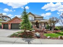 Beautiful two-story home with brick accents, mature landscaping, and attached two car garage at 9164 E Lost Hill Trl, Lone Tree, CO 80124