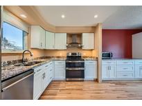 Bright kitchen features granite countertops, stainless steel appliances, and white cabinetry at 2446 S Vaughn Way # A, Aurora, CO 80014