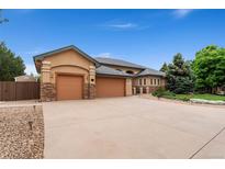 Charming home boasting a three-car garage, stone accents, and a spacious driveway at 3806 S Dawson St, Aurora, CO 80014