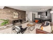 Open living room showcases a wood accent wall with a modern kitchen in the background at 1121 Albion St # 809, Denver, CO 80220