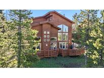 Stunning exterior elevation with wood siding, large windows and deck with trees on the property at 180 Emmett Lode Rd, Breckenridge, CO 80424
