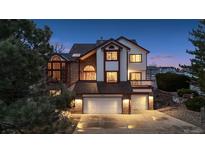 Charming two-story home with a brick and white facade, two-car garage, and professionally landscaped yard at 15935 W 77Th Pl, Arvada, CO 80007