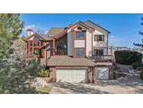 Inviting two-story home featuring a two-car garage and charming red trim at 15935 W 77Th Pl, Arvada, CO 80007