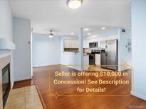 Bright living room flowing into the kitchen featuring stainless steel appliances, creating an open and airy space at 7234 E 38Th Ave, Denver, CO 80207