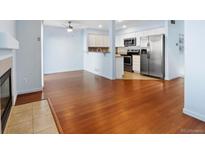 Open living area featuring hardwood floors and a modern kitchen with stainless steel appliances at 7234 E 38Th Ave, Denver, CO 80207