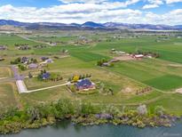 Expansive aerial view shows the property with surrounding fields and mountain views at 2366 Shoreside Dr, Berthoud, CO 80513