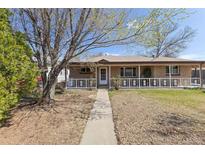 Charming single-story home with a welcoming front porch and beautifully maintained landscaping at 9410 Cedar Ct, Thornton, CO 80229