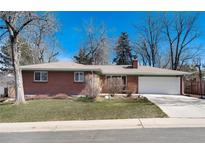 Cozy brick home featuring an attached two-car garage and a well-maintained front yard at 6930 S Delaware St, Littleton, CO 80120