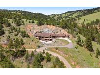 Expansive, multi-level home featuring a long driveway and beautiful landscaping nestled in a serene mountain setting at 21609 Clarence Ln, Golden, CO 80401