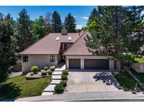 Charming home with a terracotta tile roof, an attached two car garage, and mature landscaping at 5672 S Hanover Way, Greenwood Village, CO 80111