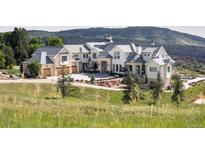 Expansive luxury home boasting stone accents, neutral paint, three-car garage, and mountain views at 9356 Cherrywood Trl, Littleton, CO 80127