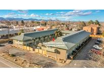 Multi-Gathering complex with mountain views, green facade, grey roofs, and ample parking in a residential neighborhood at 9925 W 20Th Ave # 17, Lakewood, CO 80215