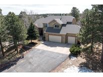 Beautiful home featuring a three-car garage, mature trees, and a well maintained lawn at 19375 Sherwood Trl, Monument, CO 80132