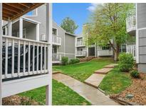 Exterior view of apartments surrounded by well-maintained grass and walkways at 4460 S Pitkin St # 119, Aurora, CO 80015