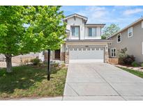 Charming two-story home boasts stone accents, a well-manicured lawn, and a spacious two-car garage at 10681 Cherrybrook Cir, Highlands Ranch, CO 80126