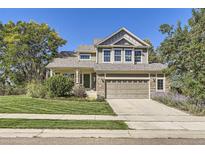 Charming two-story home with a well-manicured lawn, an attached garage, and tasteful landscaping at 124 Northrup Dr, Erie, CO 80516
