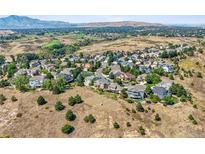 Expansive aerial view of a quiet neighborhood nestled in a landscape with rolling hills and mountain views at 10520 W Vassar Dr, Lakewood, CO 80227