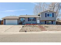 Charming, split-level home with a two-car garage, well-lit stairway, and curb appeal at 8289 Race St, Denver, CO 80229