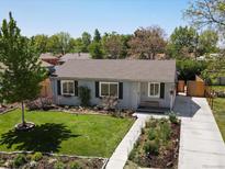 Charming single-story home featuring a well-manicured front yard with mature landscaping, new sidewalk, and a cozy front porch at 4740 W Wyoming Pl, Denver, CO 80219