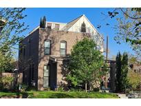 Stunning exterior of a brick home with a rooftop terrace and mature trees at 501 S Race St, Denver, CO 80209