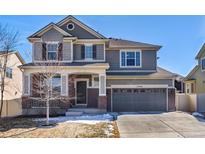 Inviting two-story home featuring a brick-accented front porch and a well-maintained lawn at 17806 Coral Burst St, Parker, CO 80134
