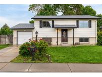 Charming two-story home featuring manicured lawn, attached garage, and inviting front porch at 7912 Fenton St, Arvada, CO 80003