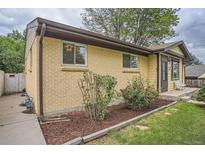 Charming brick home with a well-manicured garden and a cozy, inviting entrance, perfect for curb appeal at 7618 Umatilla St, Denver, CO 80221