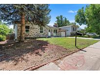 Charming single-story home features stone accents, a well-maintained lawn, and mature trees at 2260 S Lewiston St, Aurora, CO 80013