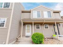 Charming townhouse featuring a covered entryway with decorative shrubbery and a welcoming front door at 11147 W 17Th Ave # 103, Lakewood, CO 80215
