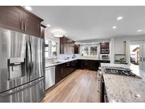 Modern kitchen featuring stainless steel appliances, granite countertops, and dark wood cabinets at 11355 Haswell Dr, Parker, CO 80134