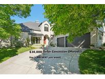 Inviting home featuring a manicured lawn, mature trees, and an attached two car garage at 7081 Salvia St, Arvada, CO 80007