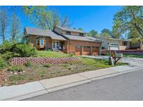 Charming brick home with a well-maintained lawn, a three-car garage, and a welcoming front porch at 128 Baylor Dr, Longmont, CO 80503