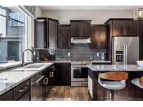 Modern kitchen features dark cabinetry, stainless steel appliances, and granite countertops at 12387 W 51St Ave, Wheat Ridge, CO 80033