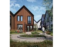 Modern townhome with wood siding, black trim, and a landscaped front yard offering a peaceful outdoor setting at 9171 W Eaton St, Westminster, CO 80031