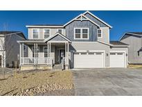 Charming two-story home boasts a three-car garage and inviting covered front porch at 39887 Floyd St, Elizabeth, CO 80107