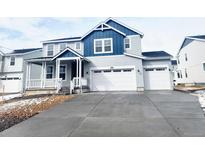 Charming two-story home featuring a three-car garage, inviting front porch, and classic blue and gray accents at 39887 Floyd St, Elizabeth, CO 80107