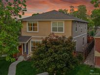 Two-story home with neutral siding, mature trees, well-kept lawn and inviting walkway leading to the front door at 3612 Hudson St, Denver, CO 80207