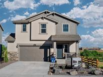 Charming two-story home with a covered front porch, neutral siding and a two-car garage at 903 W Beverly St, Elizabeth, CO 80107