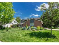 Charming two-story brick home with well-manicured lawn and colorful landscaping at 10289 E Berry Dr, Greenwood Village, CO 80111
