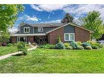 Charming two-story home with well-maintained lawn, lush landscaping and inviting entrance at 10289 E Berry Dr, Greenwood Village, CO 80111